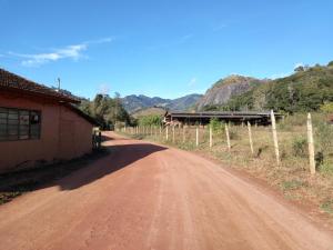 a dirt road next to a building and a fence at Recanto Flor de lis in Gonçalves