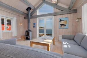 a living room with a couch and a wood stove at Lofoten Cottages by Nusfjord in Nussfjord