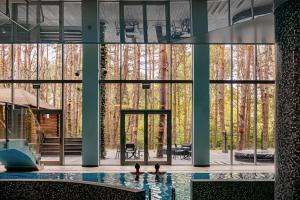 a pool in a building with a large window at Hotel Uroczysko in Cedzyna