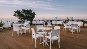a group of tables and chairs on a deck at Mangia's Pollina Resort in Cefalù