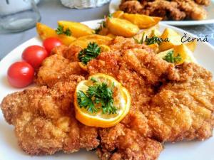 a plate of food with chicken and fruit on it at Pension Bílý Hořec in Vrchlabí