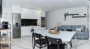 eine Küche und ein Wohnzimmer mit einem Tisch und Stühlen in der Unterkunft Casa da Barca in Vila Nova de Foz Côa