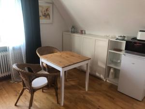 a kitchen with a table and two chairs and a table at Ferien- und Messeappartement Schwaig in Schwaig bei Nürnberg