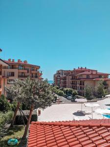 a view of a beach with some buildings and a tree at SUNNY Star Dreams CONDO w PRIME LOCATION, POOL, SEA VIEW in Sveti Vlas +16 photos