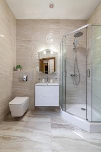 een badkamer met een douche, een toilet en een wastafel bij Alfa Apartments Svobody 39 in Lviv