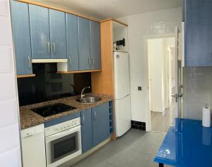 a kitchen with blue cabinets and a white refrigerator at Tunel10 in Zamora