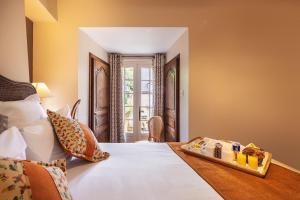 a bedroom with a bed with a tray of food on it at Hôtel La Couleuvrine Sarlat Centre Ville in Sarlat-la-Canéda