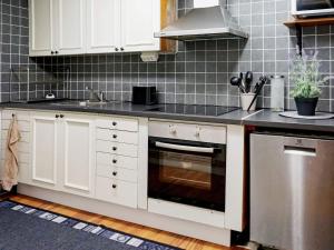 a kitchen with white cabinets and a stove top oven at 6 person holiday home in VISBY in Visby