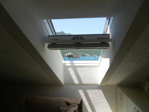 a skylight in a room with a window at Apartments David in Perast