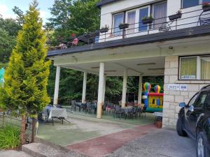 a house with a patio with tables and chairs at Bungalov camp Borasnica in Jezero