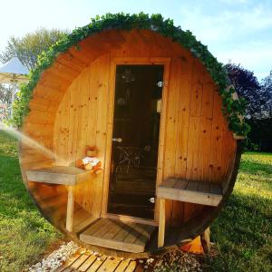 a small wooden sauna with a wooden door and benches at Holiday Inn Express Strasbourg - Sud, an IHG Hotel in Geispolsheim