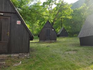 a group of barns in a field with trees at Bungalov camp Borasnica in Jezero