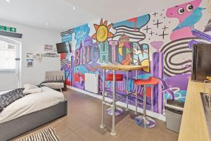 a bedroom with a mural on the wall at Artist Studio - By My Getaways in Brighton & Hove