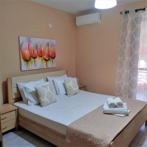 een slaapkamer met een groot bed en handdoeken bij Nini's House 1 in Nydri