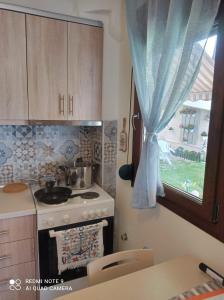 a kitchen with a stove and a window at Sunset Apartment in Epanomi