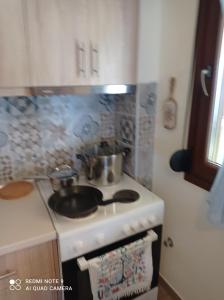 a kitchen with a stove with a pot on it at Sunset Apartment in Epanomi