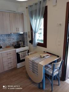 a kitchen with a table and chairs in a room at Sunset Apartment in Epanomi