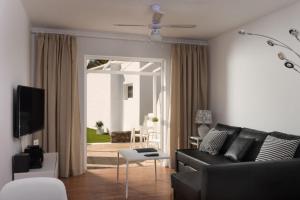 a living room with a black couch and a table at Villas New Lanzasuites in Playa Blanca