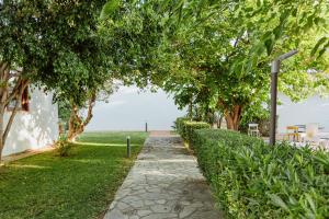 ポザーダにあるResort Fior di Sardegnaの木々や芝生が茂る公園内の散歩道