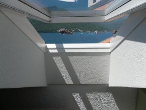 a window in a room with a view of the water at Apartments David in Perast