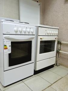 two white ovens sitting next to each other in a kitchen at Гостиница-Хостел на Промышленной in Ryazan
