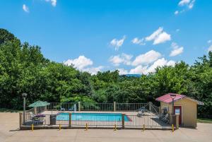 a swimming pool in a park with a playground at Quality Inn & Suites Hot Springs - Lake Hamilton in Hot Springs
