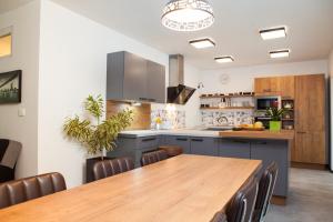 a kitchen with a wooden table and a dining room at Bella Belca in Mojstrana