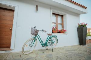 Una bicicleta azul estacionada frente a una casa en Resort Fior di Sardegna en Posada