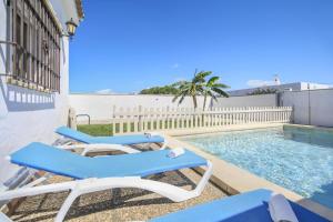 patio z 2 leżakami i basenem w obiekcie Villa Ibicenca w mieście Vejer de la Frontera
