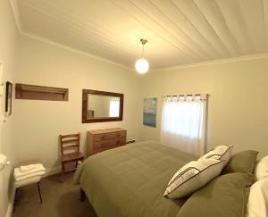 a bedroom with a bed and a dresser and a mirror at Loose Leaf Cottage in Kyneton