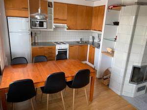 a kitchen with a wooden table and black chairs at Karhunvartijan Pirtti 5A5 in Kuusamo