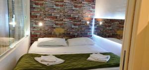 Ce lit se trouve dans une chambre dotée d'un mur en briques. dans l'établissement Domatia, à Barletta