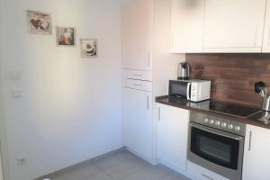 a kitchen with a stove and a microwave at Ferienhaus mit Terrasse - Wallbox in Bad Oeynhausen