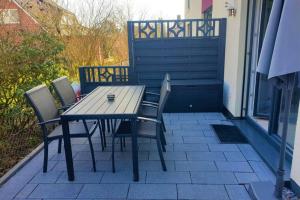a wooden table and chairs on a patio at Ferienhaus mit Terrasse - Wallbox in Bad Oeynhausen