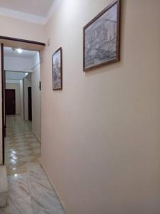 a hallway with two framed pictures on a wall at Kelany Hotel in ‘Izbat Zaydān