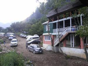 un grupo de coches estacionados fuera de un edificio en Hotel Kashmir Lodge en Bālak Bhanna