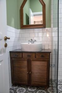 een badkamer met een wastafel en een spiegel bij Seven cafe & hotel in Pogradec
