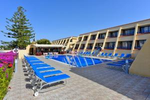 a hotel with blue lounge chairs and a swimming pool at Napa Prince Hotel Apts in Ayia Napa