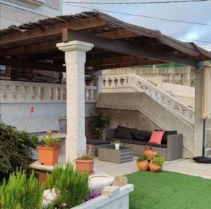 eine Terrasse mit einem Sofa unter einer hölzernen Pergola in der Unterkunft casa salvante in Moaña