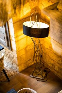 a lamp in the corner of a room at Hôtel La Couleuvrine Sarlat Centre Ville in Sarlat-la-Canéda