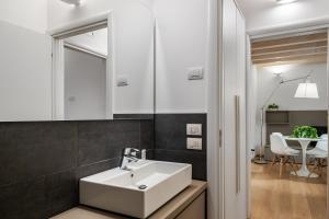 bagno con lavandino bianco e specchio di MyPlace Padova Centro Storico a Padova