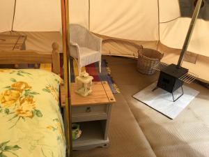 a room with a bed and a stove in a tent at Glamping at The Homestead - Ensuite bell tent in Hereford