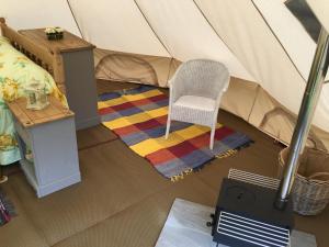 a room with a chair in a tent at Glamping at The Homestead - Ensuite bell tent in Hereford