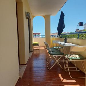 patio con mesa y sillas en el balcón en Olhos do Mar, en Albufeira