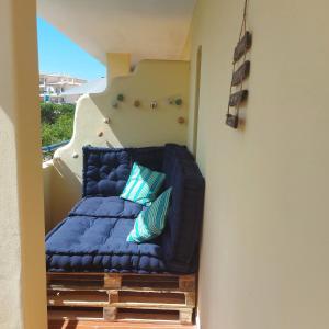 un sofá azul sentado en la parte superior de una escalera en Olhos do Mar, en Albufeira