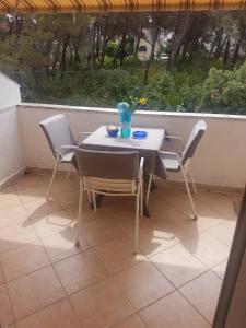 a table and chairs on a balcony with a table and a vase at Apartment Novaković in Mirce +7 photos
