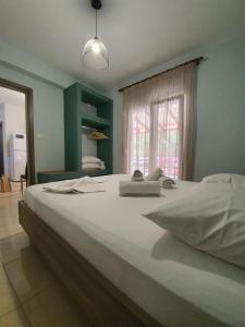 a large white bed in a room with a window at ONITES Elegant Suites in Skala Potamias