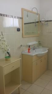 y baño con lavabo y espejo. en Hotel Casas do Sol, en São Filipe