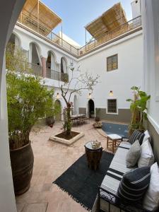 a courtyard with a couch and a table in a building at Private house Riad Arlette exclusive in Marrakesh