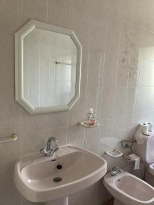 a bathroom with a sink and a toilet and a mirror at Casa do Tavares in Carvalhais +29 photos
